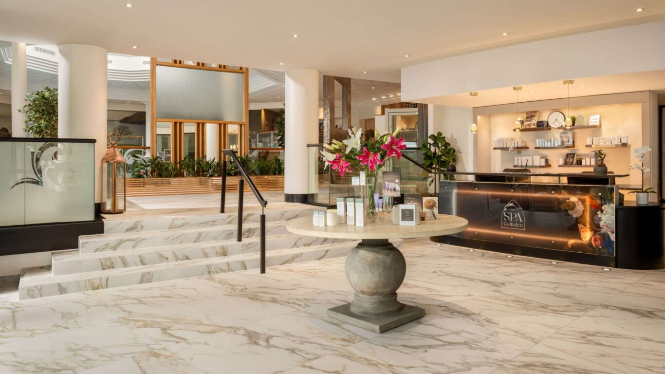 Elegant hotel spa lobby with marble floors, luxurious amenities, fresh flowers, and warm lighting for a welcoming experience.