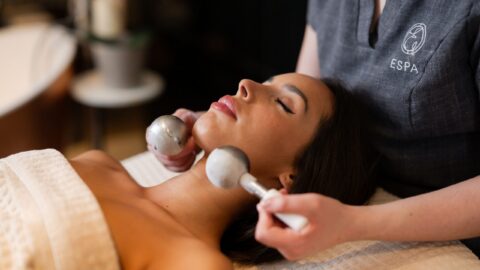 Guest enjoys relaxing facial massage at luxury hotel spa with calming ambiance and professional service.