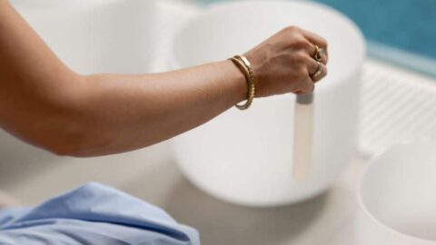 Relaxing sound bath by the hotel pool with calming white bowls and serene atmosphere.
